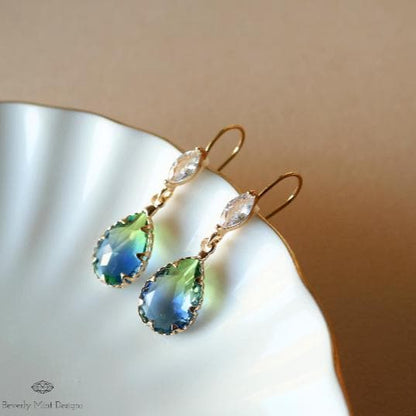 a pair of earrings sitting on top of a white plate